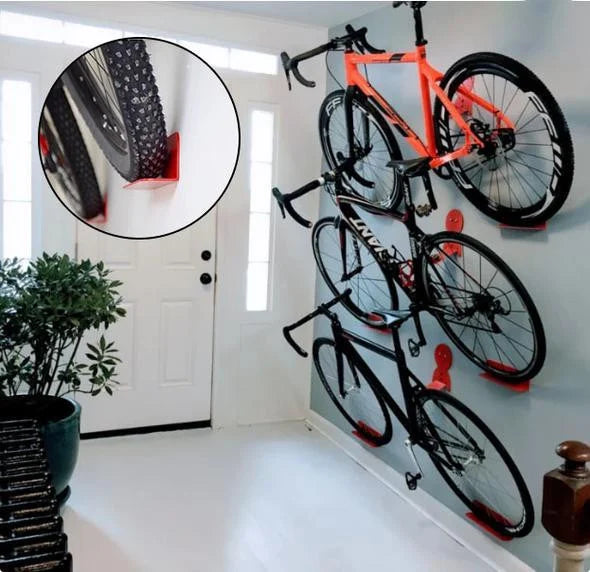 Drie racefietsen netjes verticaal opgehangen aan de muur in een garage
