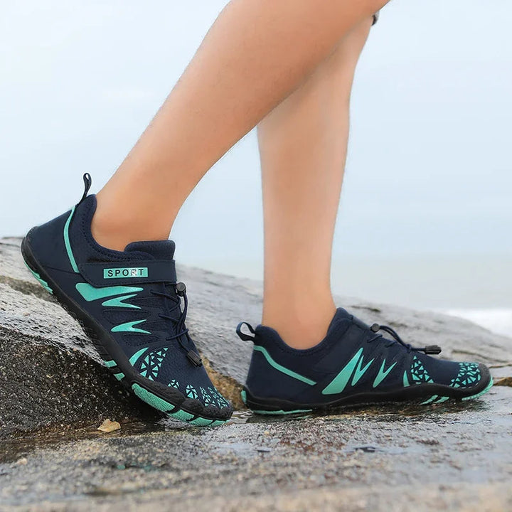 Heren waterschoenen in donkerblauw met groene accenten bij water