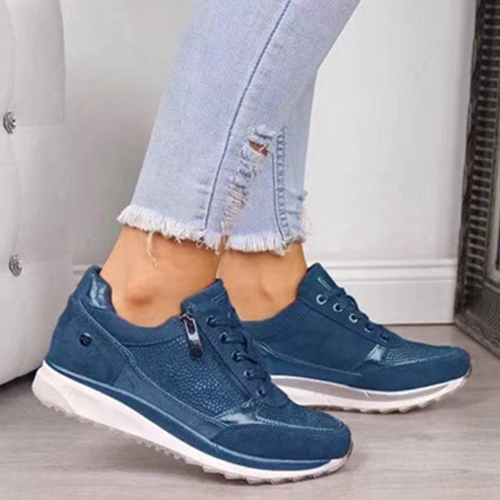 Actieve dames draagt stijlvolle blauwe orthopedische wandelschoenen tijdens een wandeling, comfortabel en sportief.