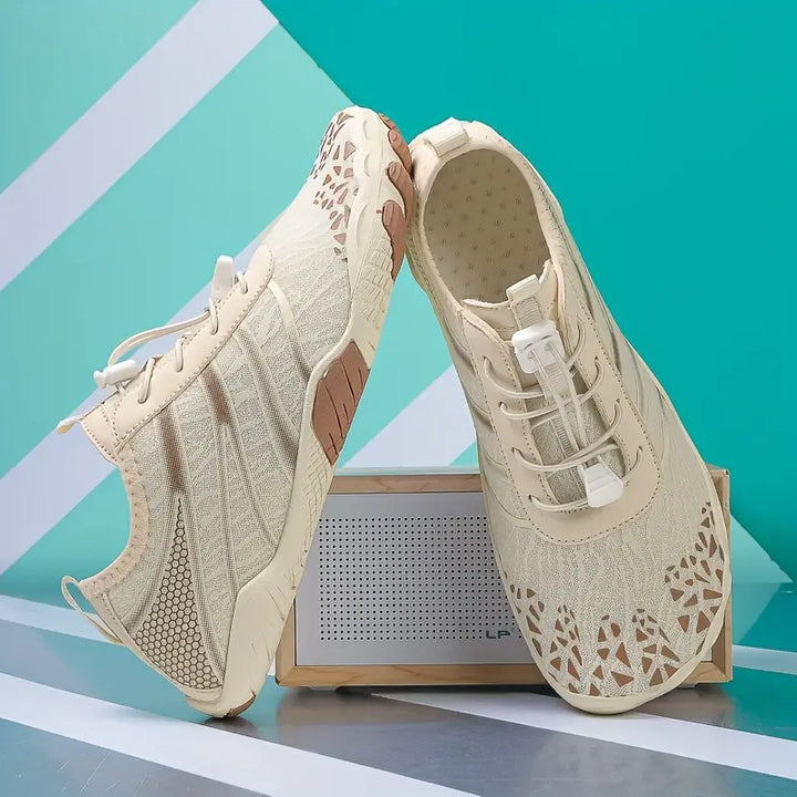 Twee beige waterschoenen, gepositioneerd als paar, benadrukken het stijlvolle ontwerp.