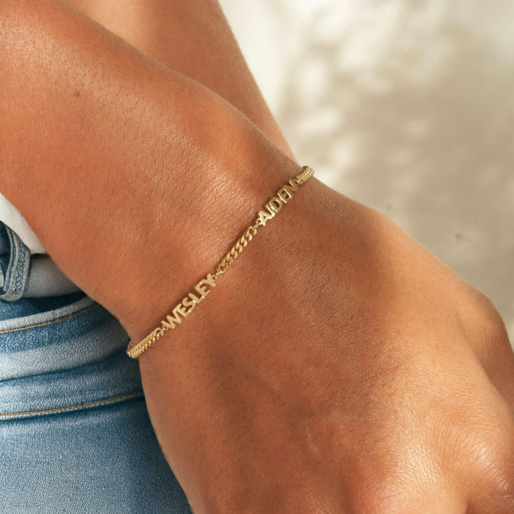 Goudkleurige unisex naamarmband met gegraveerde naam, van roestvrij staal. Stijlvol gepersonaliseerd cadeau.