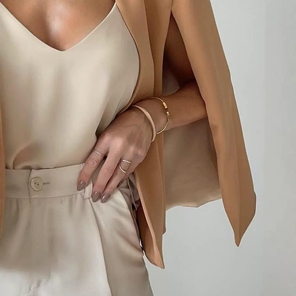 Close-up van de mouwloze opening en details van de beige blazer