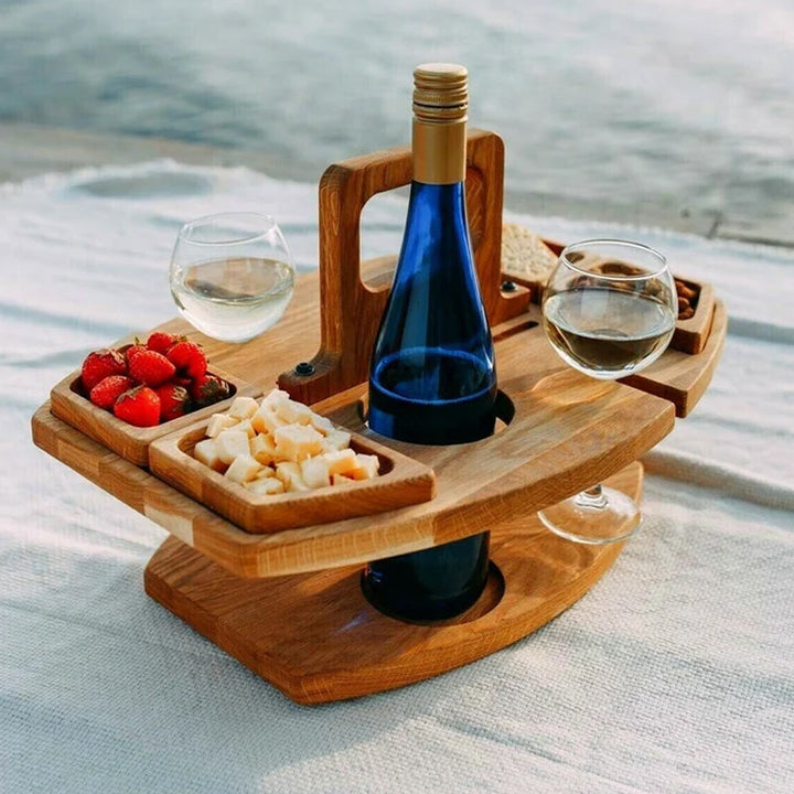 Detail van houten picknicktafel met aardbeien, kaasblokjes en wijnglas.
