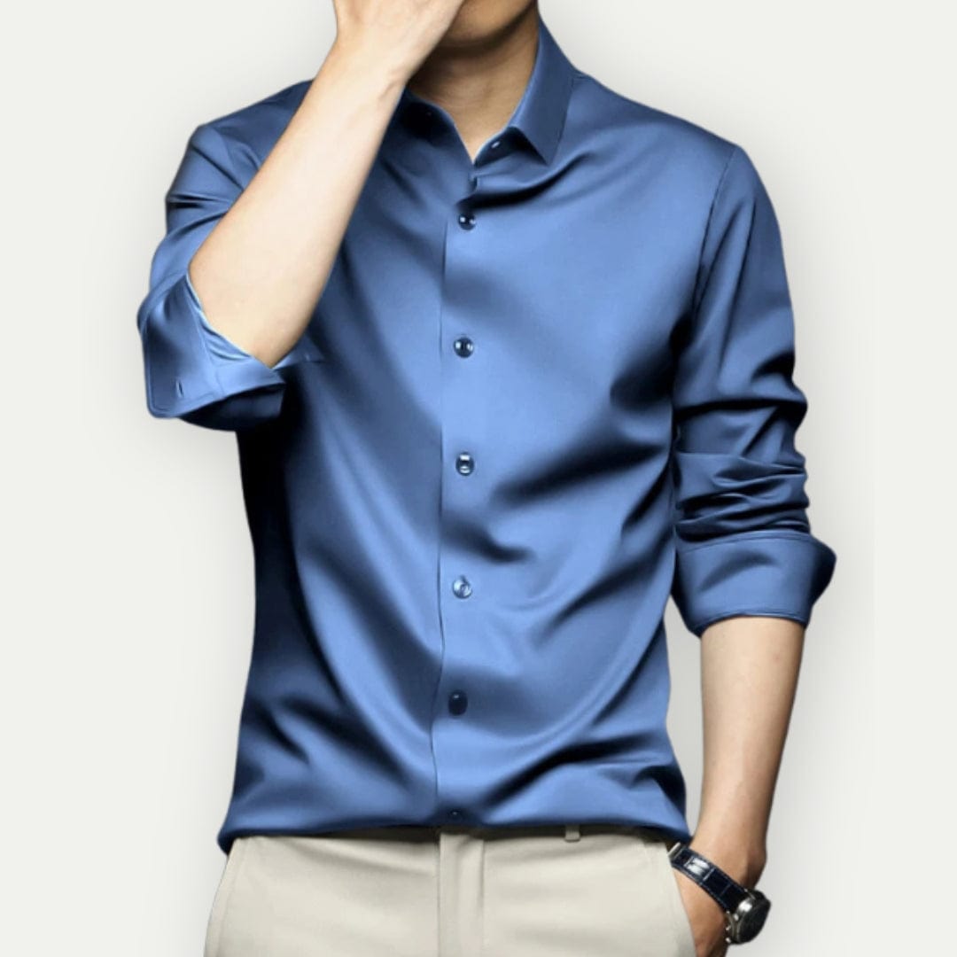 Man zittend in comfortabel kreukvrij overhemd. Slim fit herenmode voor onbeperkte bewegingsvrijheid.