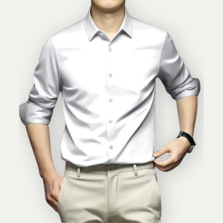 Blije man in kreukvrij slim fit overhemd. Comfortabele, stijlvolle herenmode die de hele dag perfect zit.