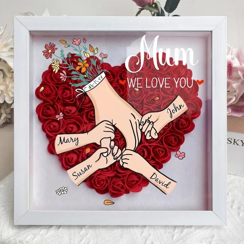 Stijlvolle decoratie voor thuis: gepersonaliseerde schaduwdoos met bloemen en familienamen.