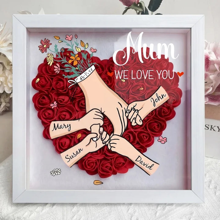 Stijlvolle decoratie voor thuis: gepersonaliseerde schaduwdoos met bloemen en familienamen.