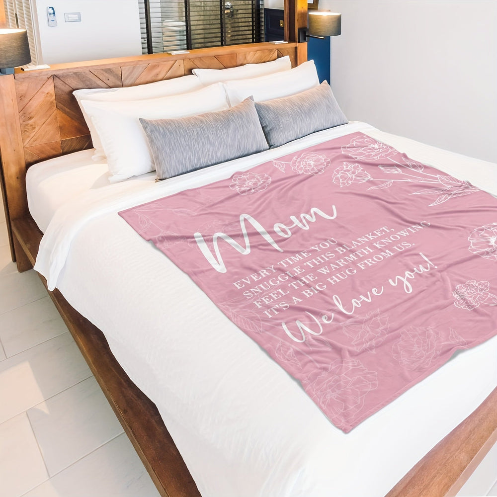 Roze flanellen deken met liefdevolle boodschap, liggend op een bed in een modern interieur