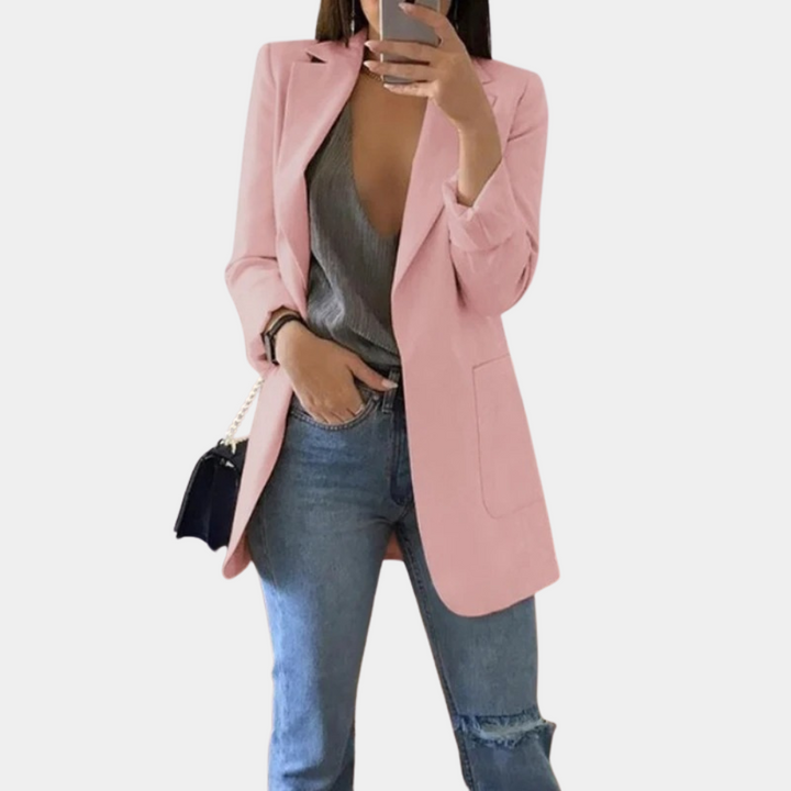 Dames draagt een roze comfortabele blazer met jeans en een handtas