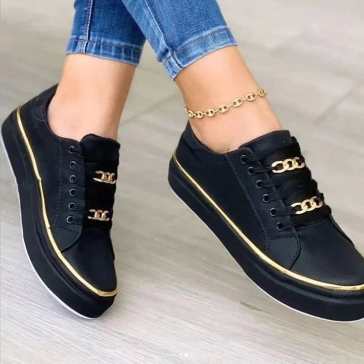 Details van stijlvolle damesschoenen met goudkleurige accenten en vetersluiting