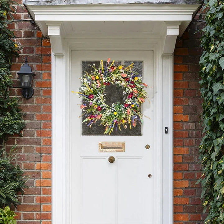 Bloomora handgemaakte bloemenkrans opgehangen aan een witte voordeur