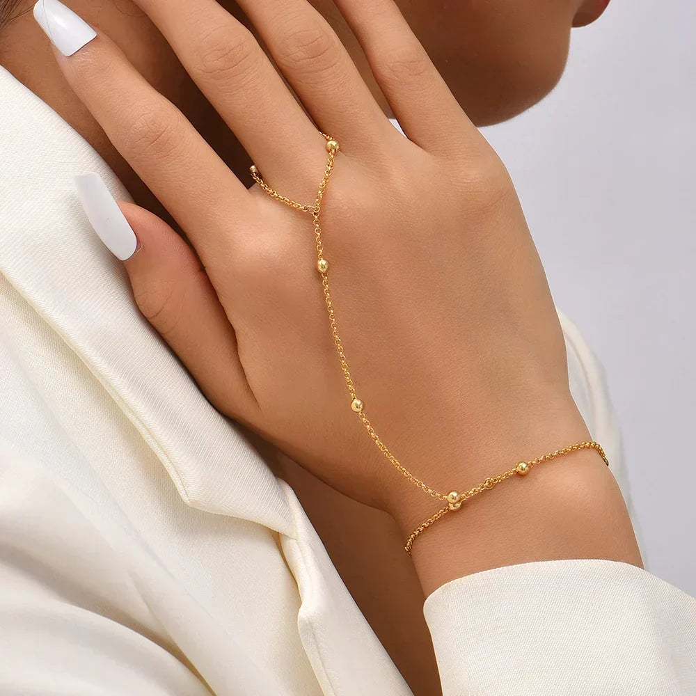 Close-up van de Aurelia handketting met delicate kralen, getoond op een vrouwenhand.