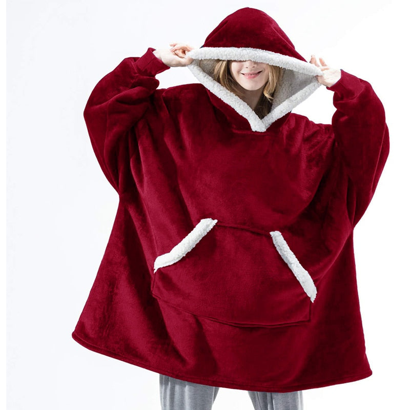 Vrouw ontspant in een knusse, zachte hoodie deken tijdens winterse avonden thuis.