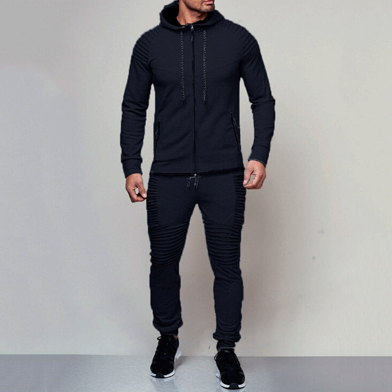 Man draagt zwart trainingspak met hoodie en comfortabele pasvorm