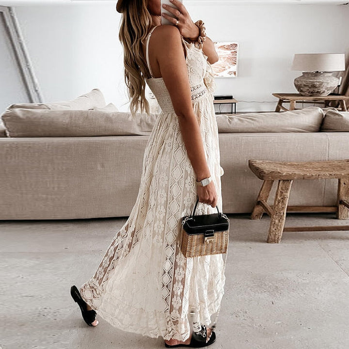 Model toont de veelzijdigheid van de maxidress, gecombineerd met sandalen en een tas.