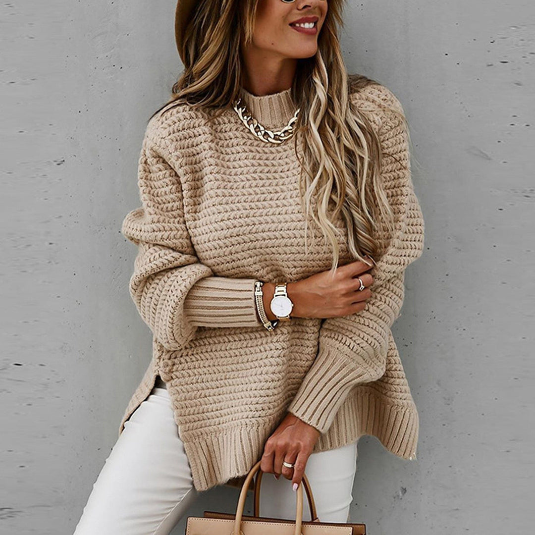 Vrouw draagt beige gebreide trui met halfhoge hals en zijsplitten, stijlvol en comfortabel
