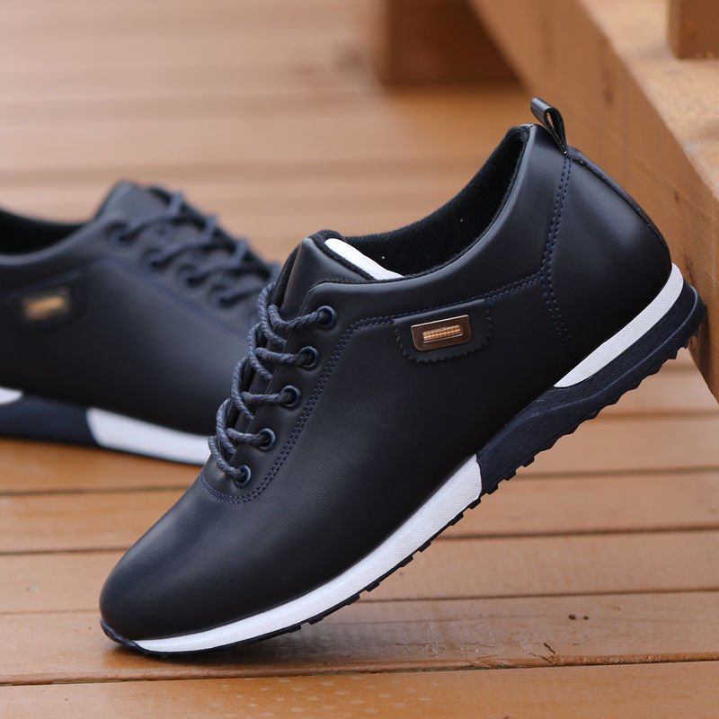 Zwarte heren casual sneakers met fluweelzachte binnenvoering op een houten vloer.