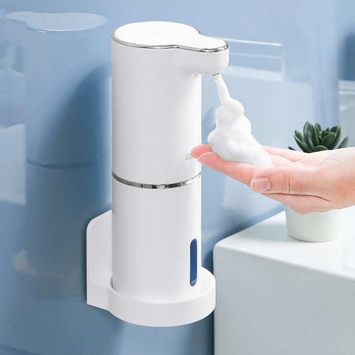 Zeepdispenser met wandhouder en rijk schuim op de hand