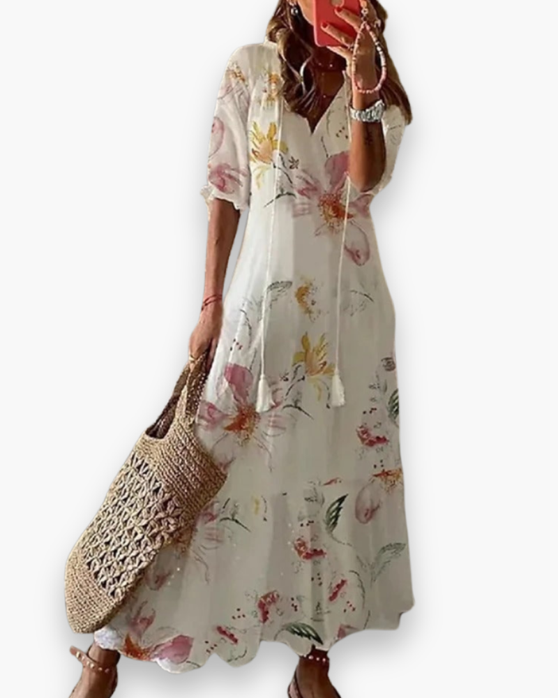 Vrouwelijke bohemien zomerjurk in het wit met bloemenprint gecombineerd met sandalen