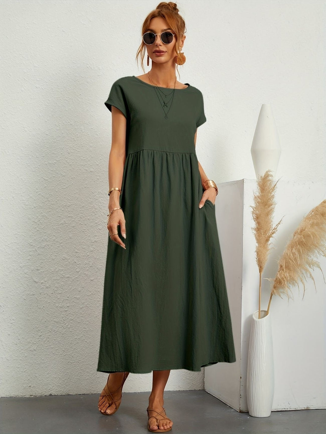 Model draagt een legergroene lichte midijurk met korte mouwen voor dames