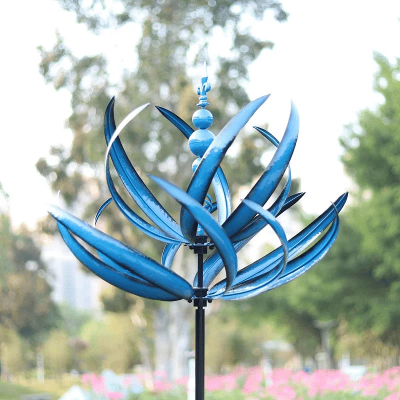 Close-up van blauw-rode decoratieve windspinner. Metalen tuinkunst die draait, voor rust in de tuin.
