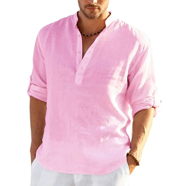 Man poseert in een stijlvol roze herenoverhemd, met opgerolde mouwen, perfect voor de zomer.
