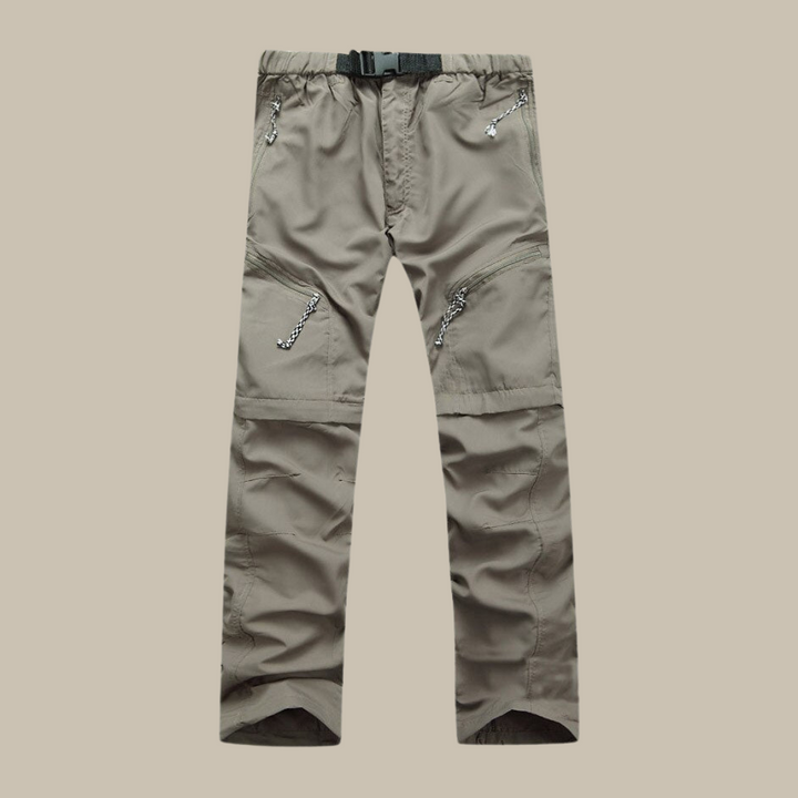 Stijlvolle man in khaki afritsbroek, genietend van een wandeling in de natuur.