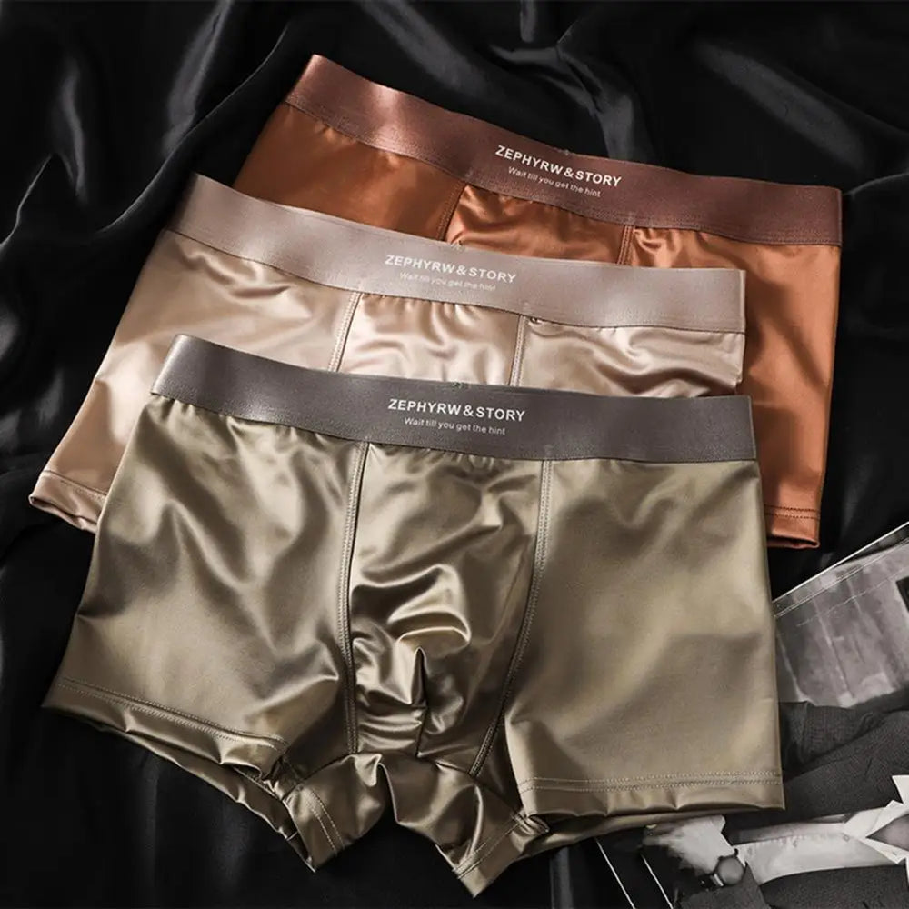 Collectie herenboxershorts in abrikoos, kaki en grijs, netjes op elkaar gestapeld.