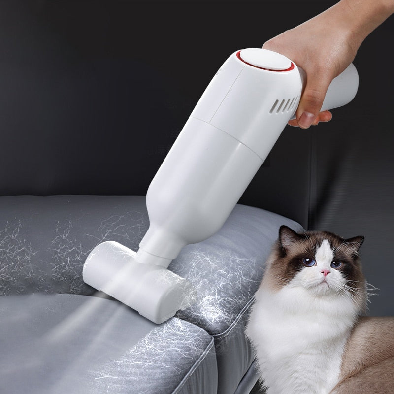 Witte draadloze stofzuiger verwijdert dierenharen van een bank naast een kat.