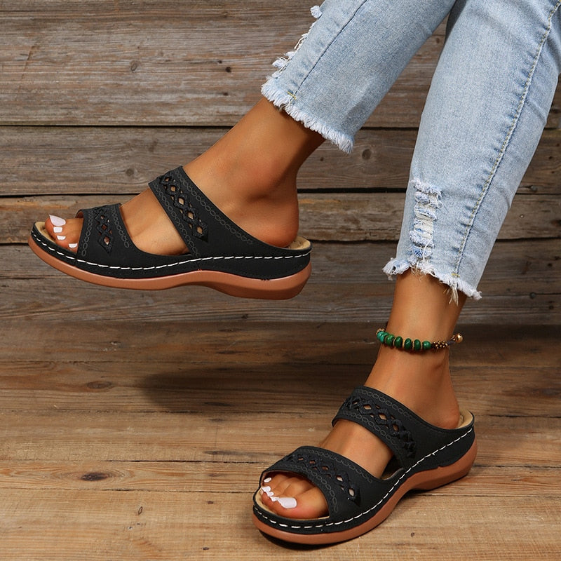 Dames orthopedische sandalen in zwart, gedragen met jeans, focus op comfortabele pasvorm.