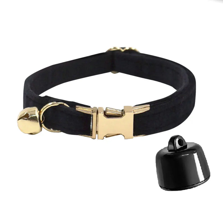 Zwarte huisdierhalsband met gouden gesp en bel, naast een compacte zwarte tracker.