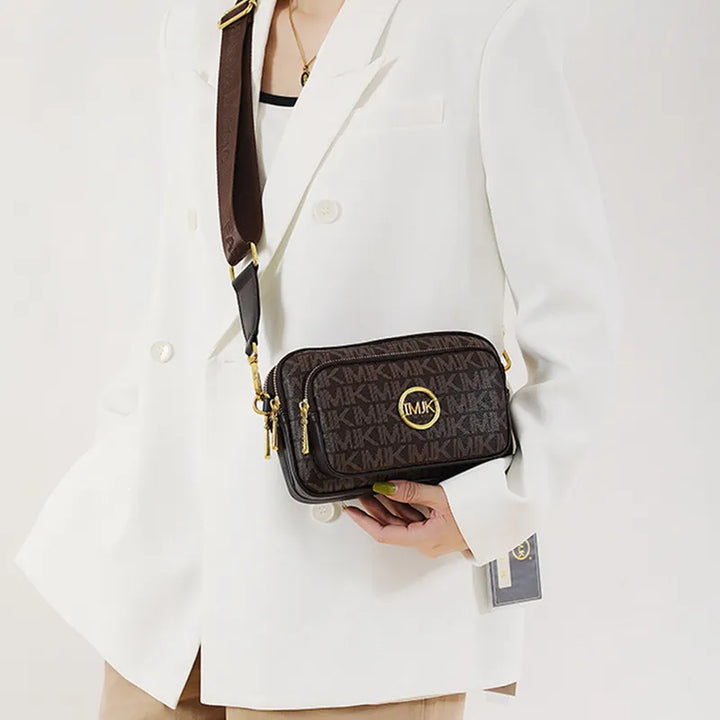 Model draagt de bruine schoudertas crossbody bij een witte blazer