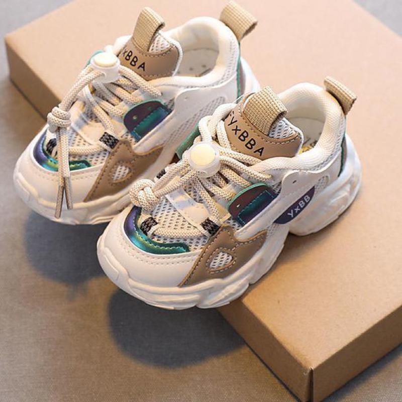 Stijlvolle beige kindersneakers op een doos
