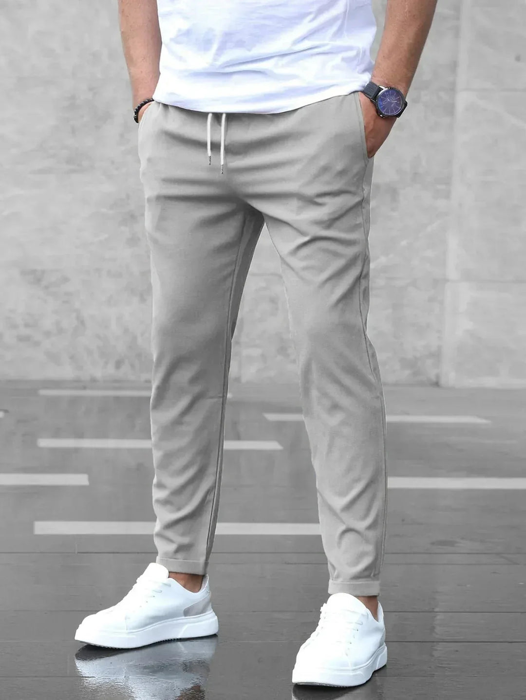 Heren slim fit broek in het grijs met elastische taille en witte sneakers
