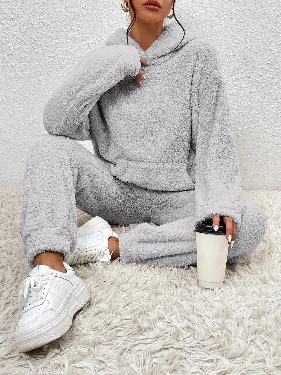 Volledig dameshuispak van zacht teddy fleece met capuchon en elastische boorden.