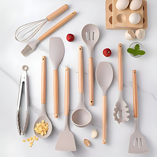 Complete set kookgerei met grijze siliconen koppen en lichte bamboe handgrepen, ideaal voor de moderne keuken.
