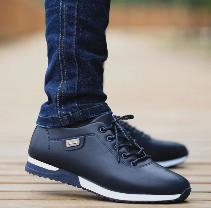 Close-up van een man die blauwe casual sneakers draagt met jeans.