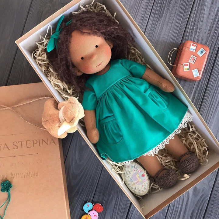 Waldorf pop op een houten bankje, roept een gevoel van rust en warmte op. Pedagogisch speelgoed.