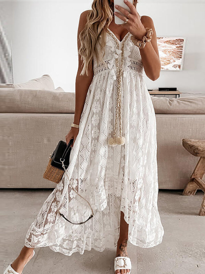 Dames Mara maxidress in het wit met V-hals en kanten details, gedragen in een lichte interieursetting.