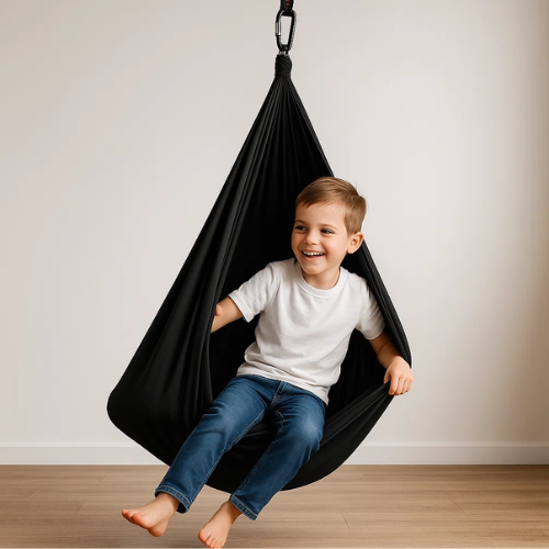 Kind ontspant in zachte katoenen therapieschommel; perfect voor sensorisch spel en innerlijke rust binnenshuis.