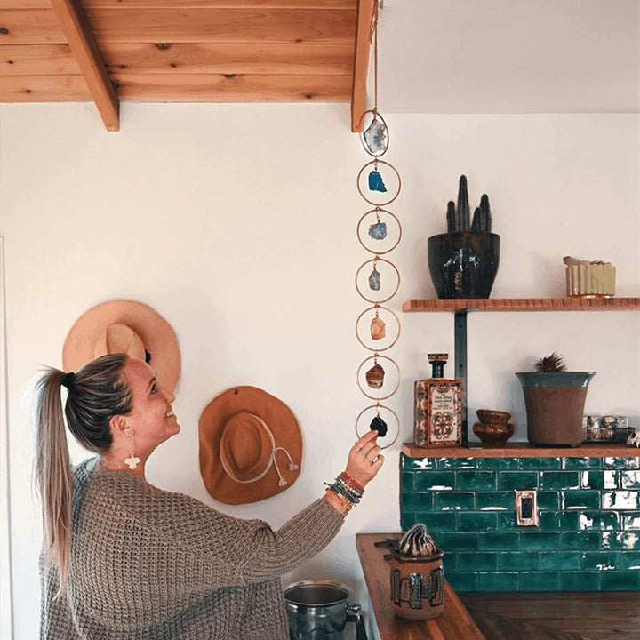 Chakra edelstenen hanger hangend aan een muur als spirituele wanddecoratie