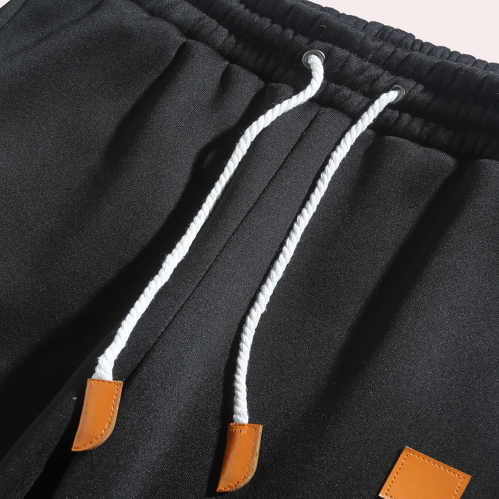 "Comfortabele heren joggingbroek met baggy pasvorm, grijs van kleur, verstelbare tailleband, ideaal voor sport en casual."