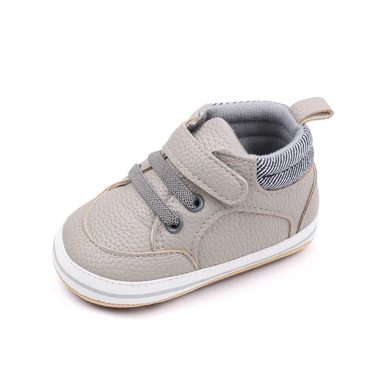 "Comfortabele leren baby schoenen, zacht en stijlvol in blauw, bruin, grijs of wit met antislipzolen voor eerste stapjes."