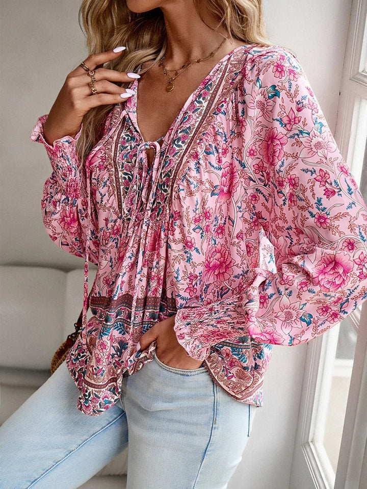 Detailopname van de roze bloemenblouse met gesmokte manchetten