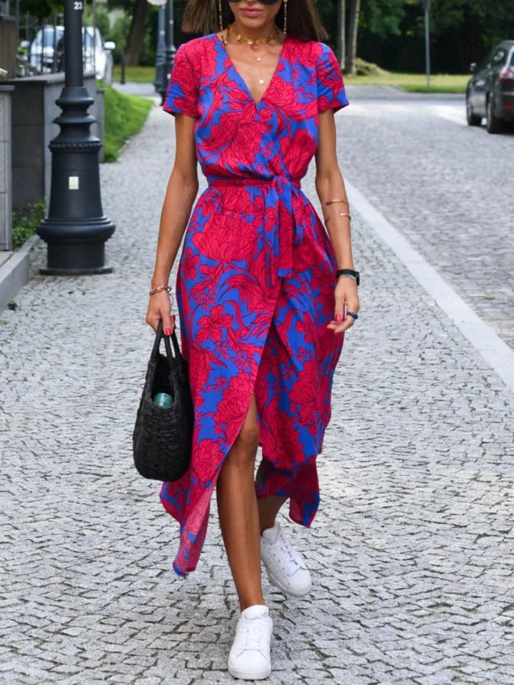 Dames bloemen wrap midi jurk in rood en blauw gedragen op straat