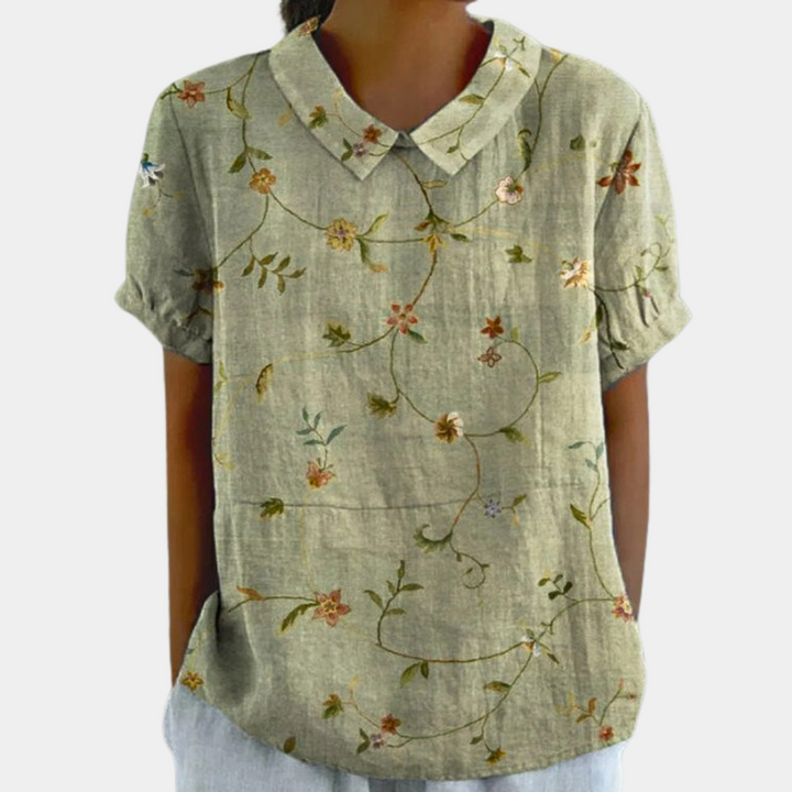 Modieuze vrouwen blouse met delicate bloemenprint, korte mouw en nette kraag. Comfortabel en trendy voorjaar.
