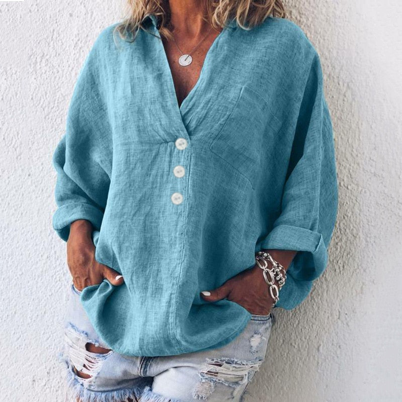 Vrouwen oversized top in helderblauw gedragen met ripped denim shorts