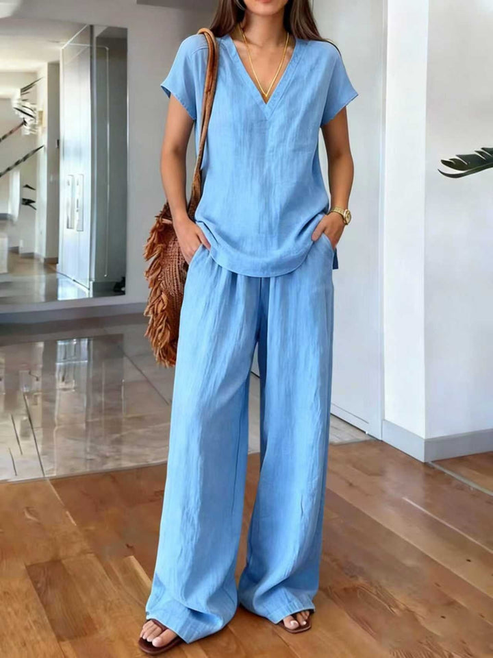 Lichte en luchtige dames tweedelige linnen set voor de zomer. Casual blouse met V-hals en lange broek.