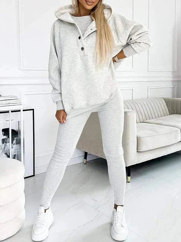 Vrouwelijke mode: complete lounge set met capuchontrui, tanktop en strakke leggings voor binnen.