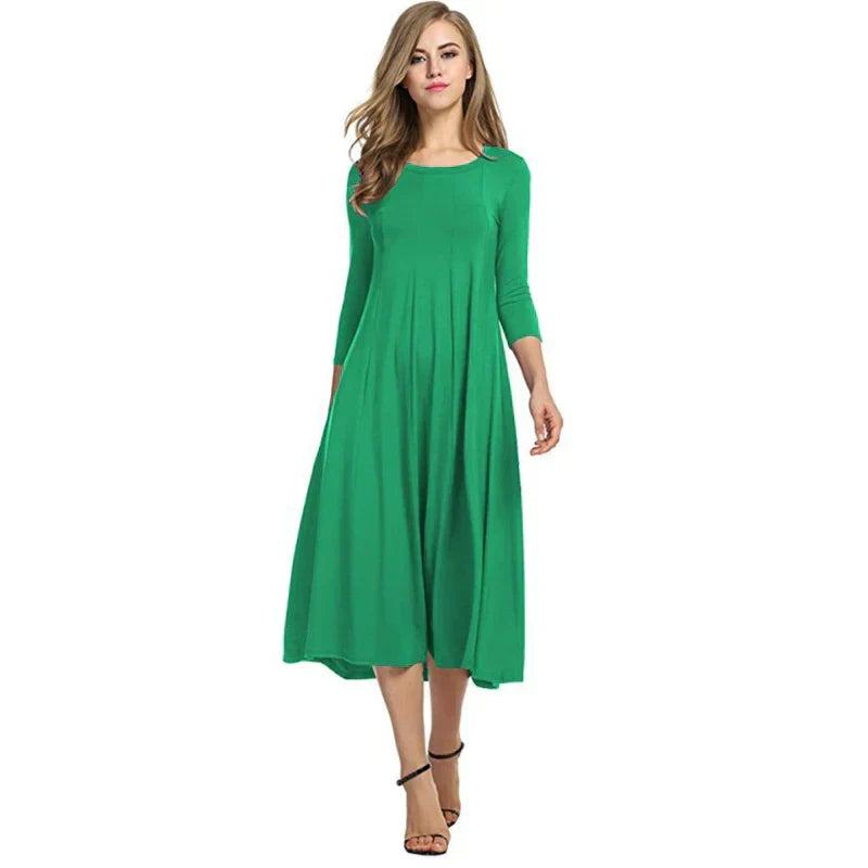 Model draagt comfortabele en stijlvolle dames driekwart midi zomerjurk met ronde hals.
